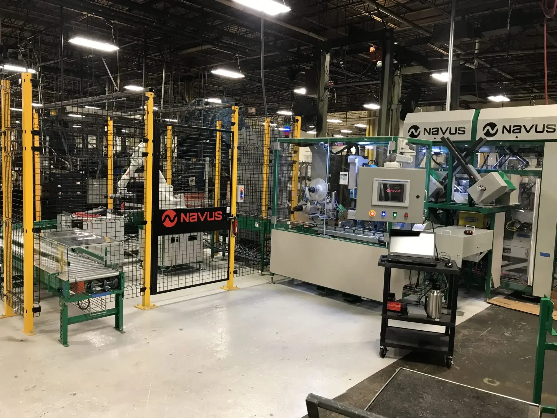 Factory robotic packaging line behind yellow safety fencing