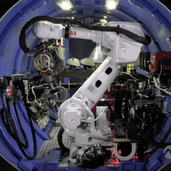 White industrial robot inside circular test cell