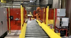 Conveyor leading into guarded robotic welding cell