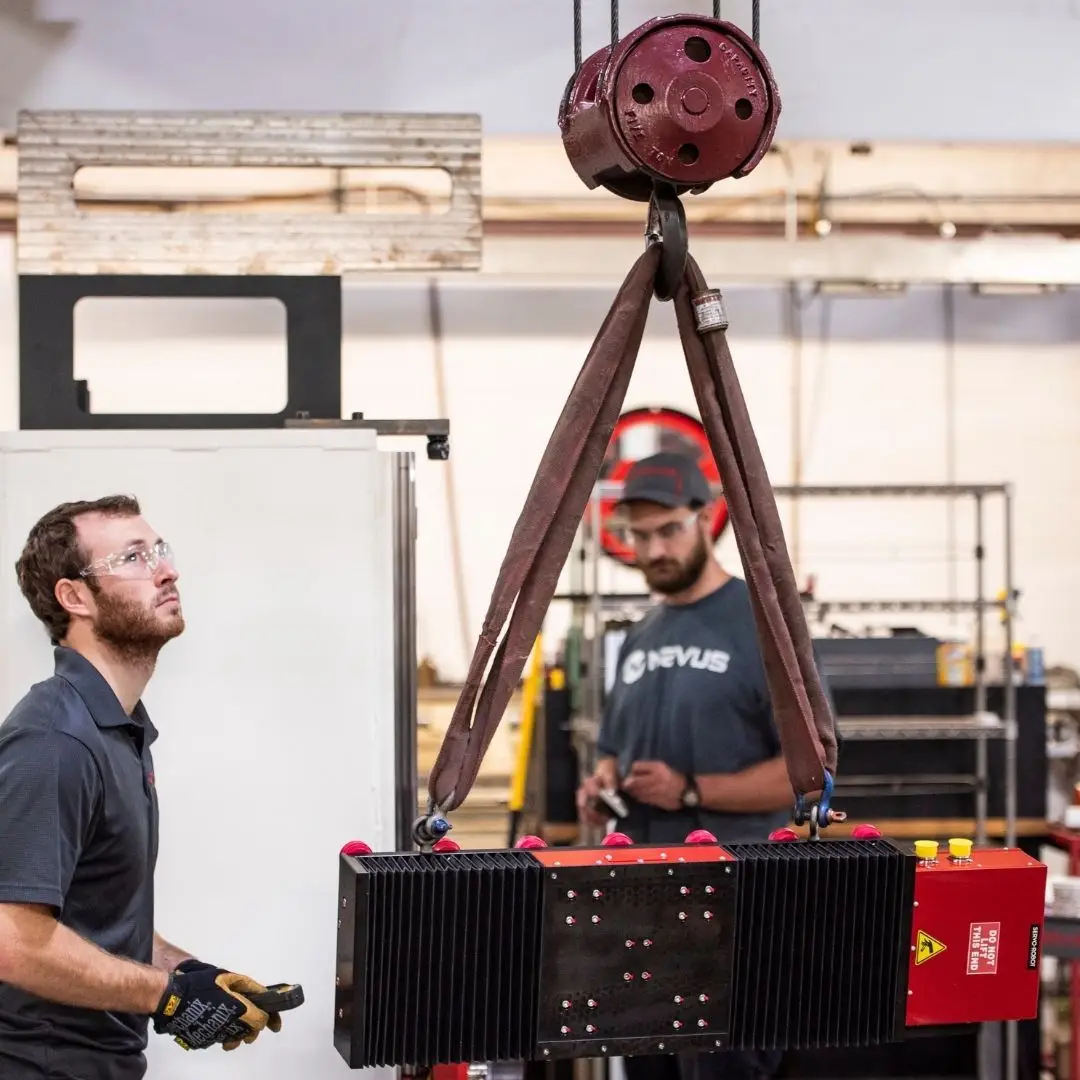 Two workers operating a heavy machinery lift.