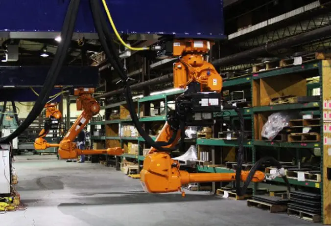 Industrial robotic arms in a warehouse setting.