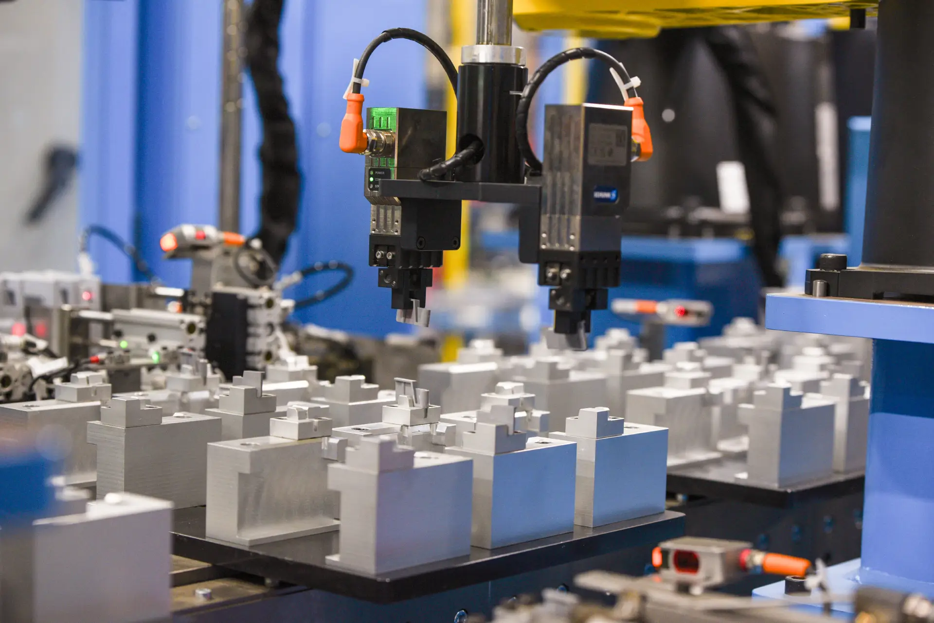 Close-up of end effector gripping machined blocks
