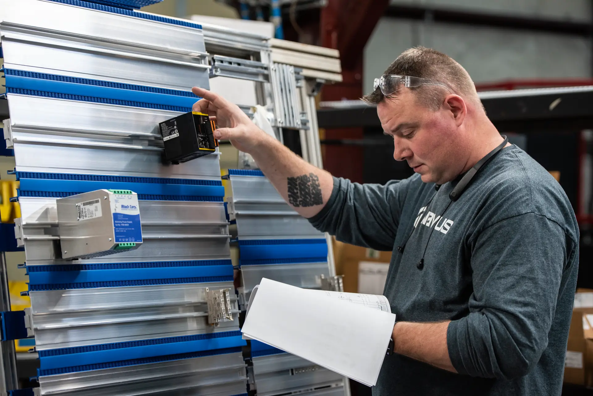 Man inspecting equipment, holding a notebook.