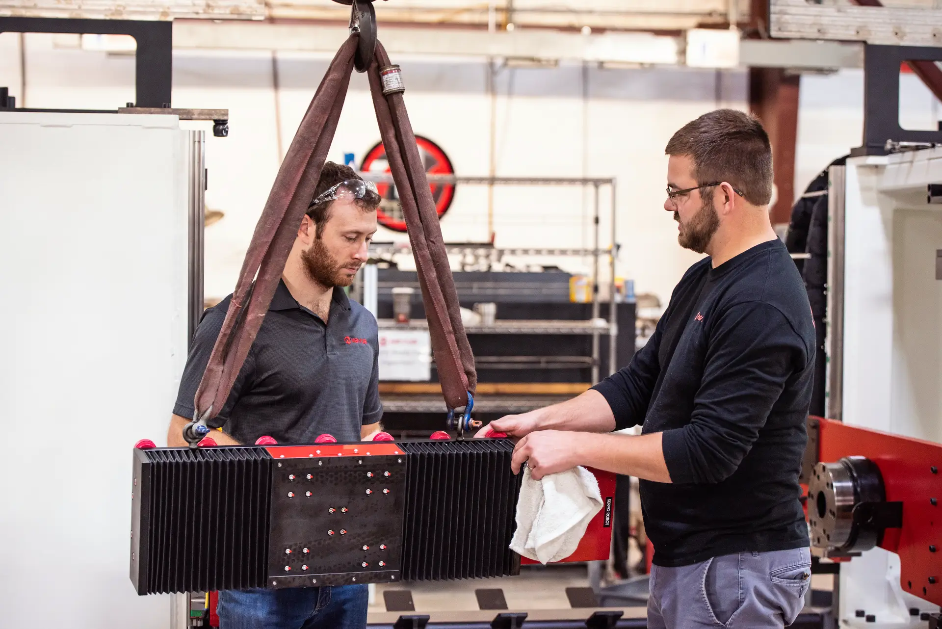 Two men inspecting industrial equipment in workshop.