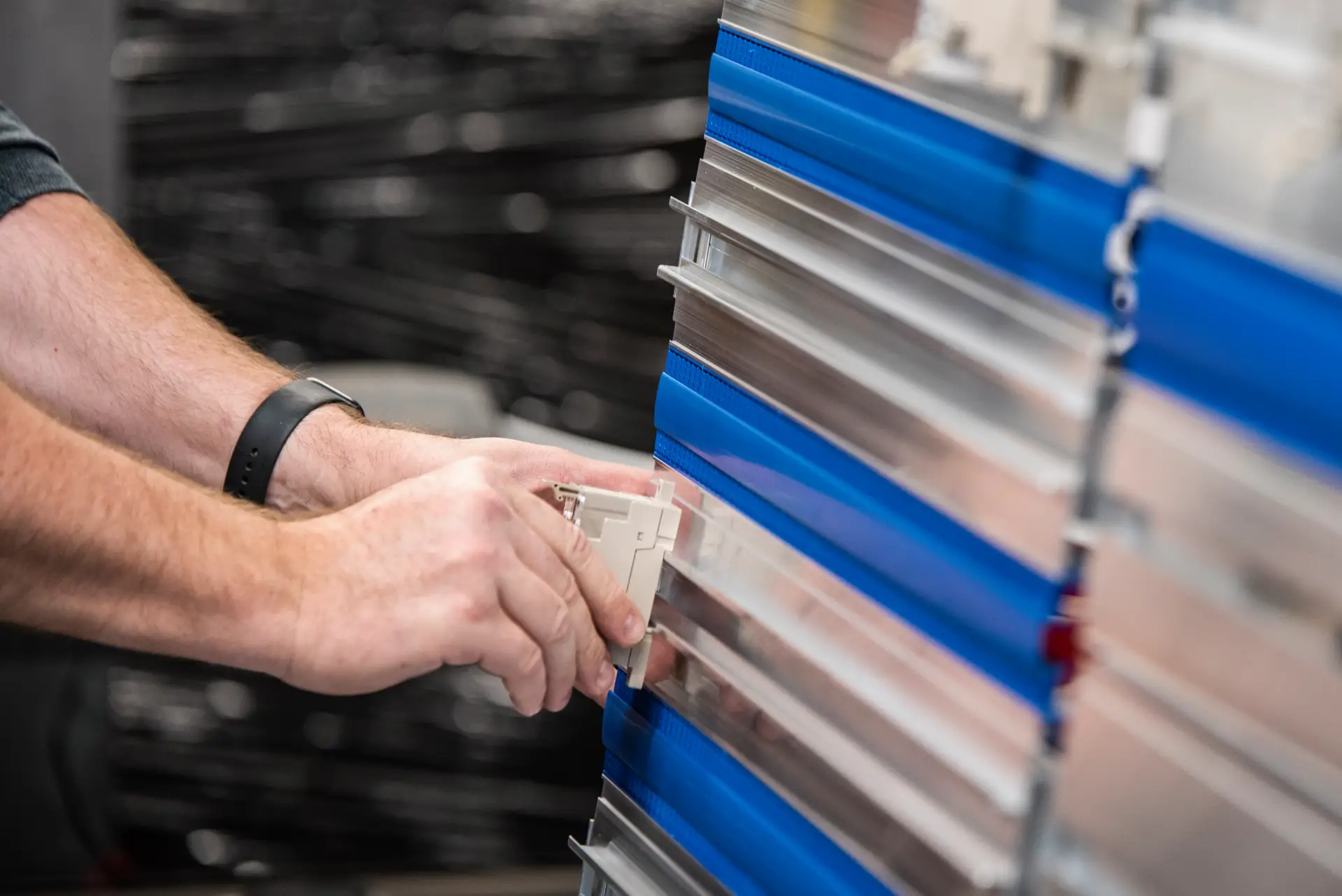 Hands working with industrial metal panels.