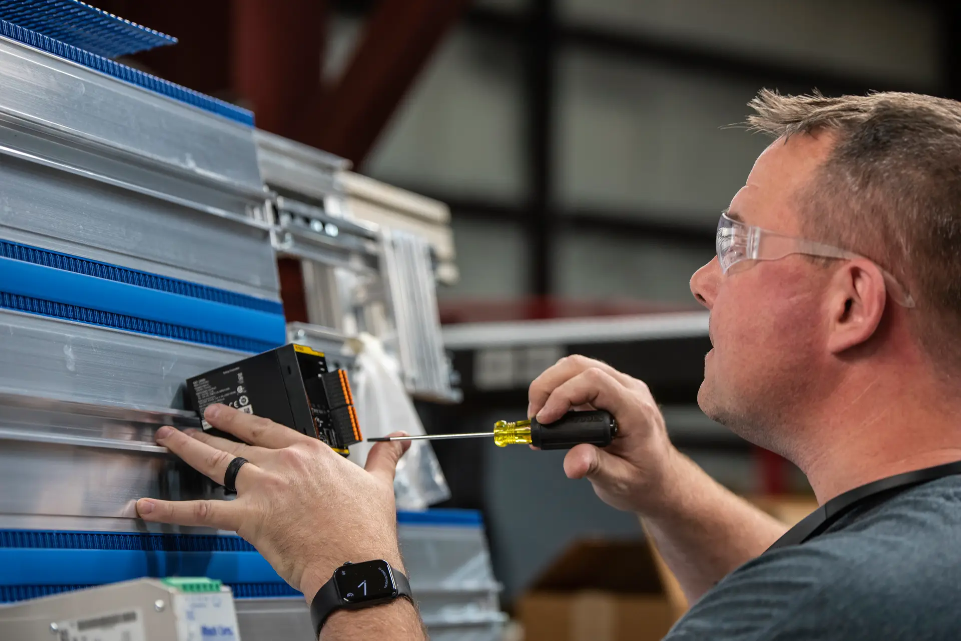 Man installing equipment with screwdriver.