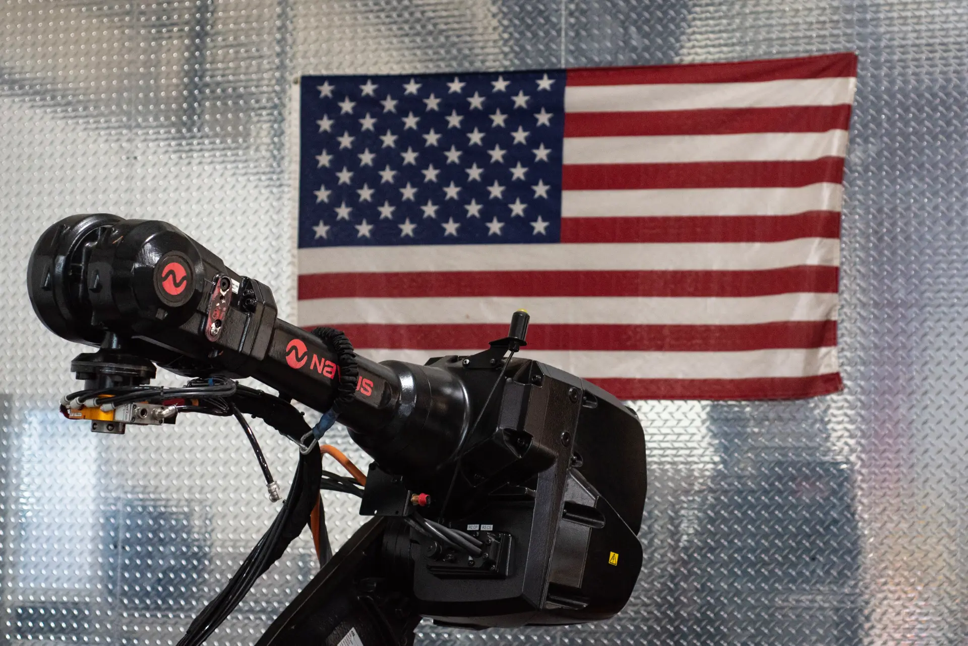 Robot arm with American flag backdrop.