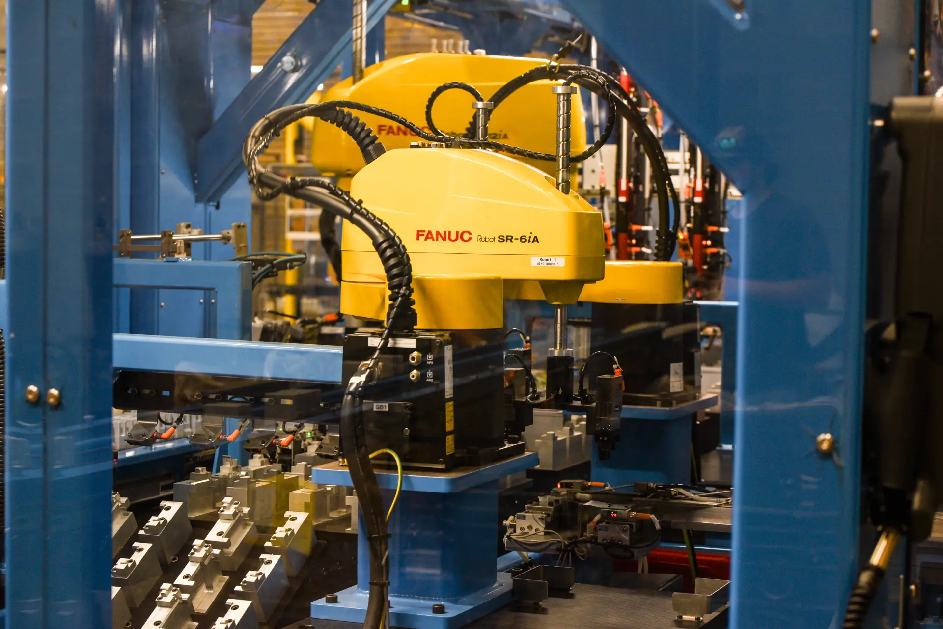 Yellow industrial robots in a manufacturing facility.